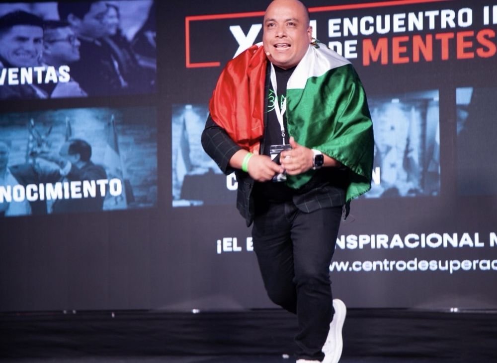 Mario Berry en el escenario con la bandera de México